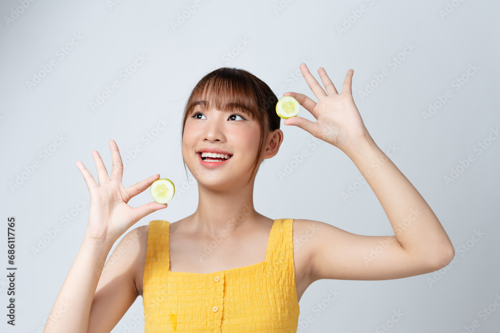 portrait of attractive asian smiling woman isolated on white studio shot eating cucumber portrait of attractive asian smiling woman isolated on white studio shot eating cucumber