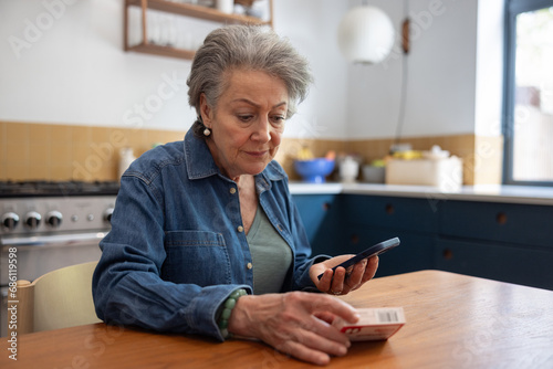 Senior woman at home using a smartphone to order prescription drugs online
