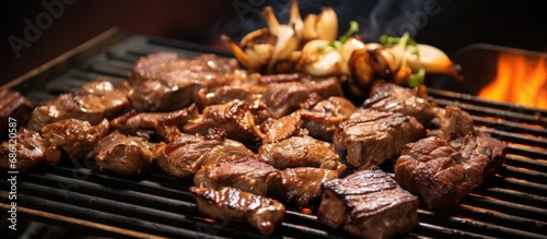 Using chopsticks, pick up mushrooms and grilled beef sirloin on a charcoal stove in Asian and Korean BBQ style. © AkuAku