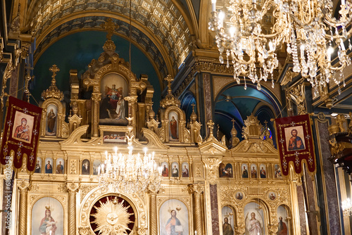 Golden altar and interior of the holy church with paintings of Maria, Joseph and Jesus - light from a golden chandelier