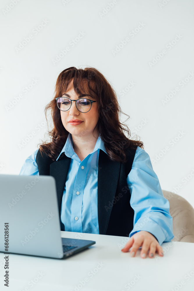 Portrait of Young Successful Caucasian Businesswoman Sitting at Desk Working on Laptop Computer in City Office. Portrait of Young Successful Caucasian Businesswoman Sitting at Desk Working on Laptop Computer in City Office.