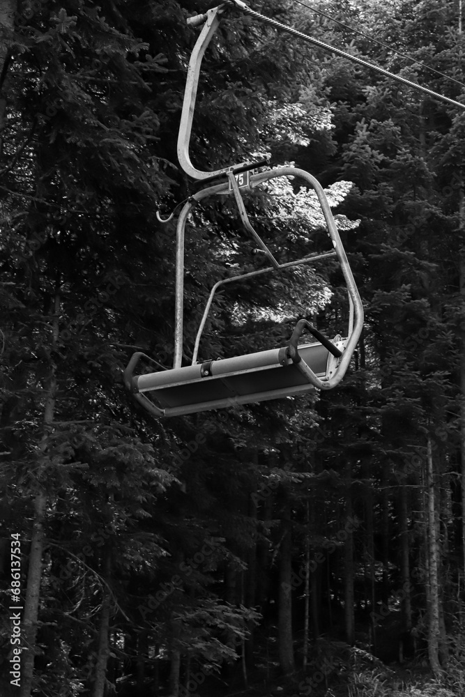 Empty ski life going upwards during the summer season in a forest background in black and white