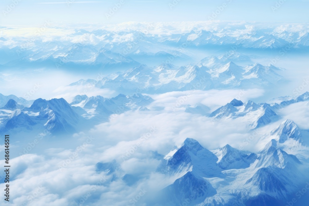  a view of the top of a mountain range from an airplane in the sky with clouds and mountains in the foreground.