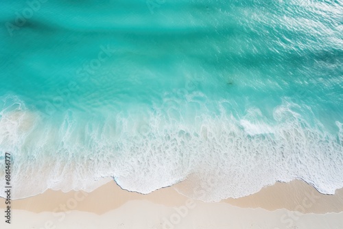  a bird's eye view of a beach with waves crashing on the sand and a surfboard in the water.