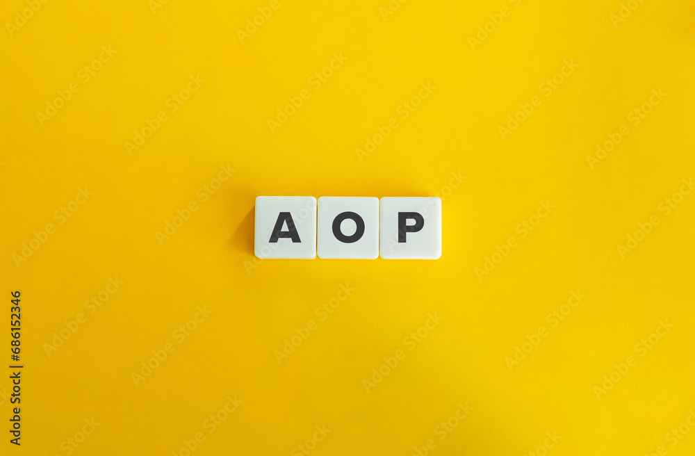 AOP Business Abbreviation on Block Letter Tiles on Yellow Background. Minimalist Aesthetics. AOP Business Abbreviation on Block Letter Tiles on Yellow Background. Minimalist Aesthetics.