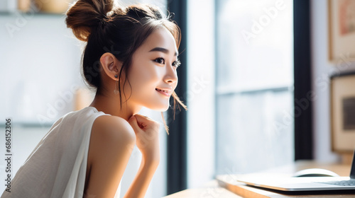 部屋でパソコンを使う若い女性 photo