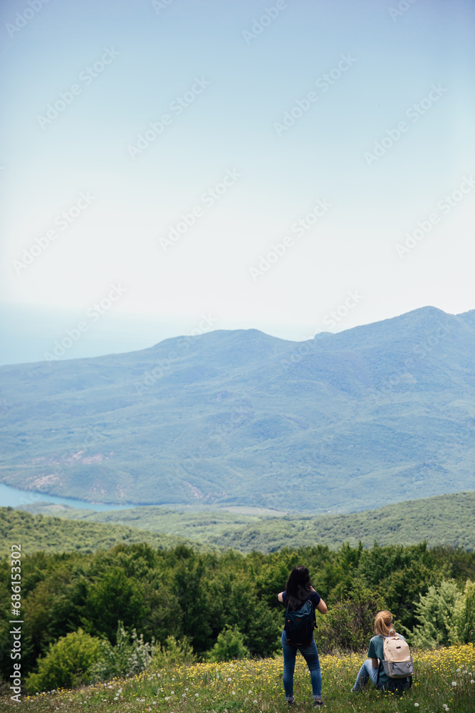 Tourist traveler on top of mountain looking at landscape