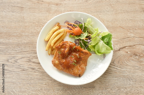 grilled chicken black pepper steak dressing spicy sauce with French fries and salad on plate 