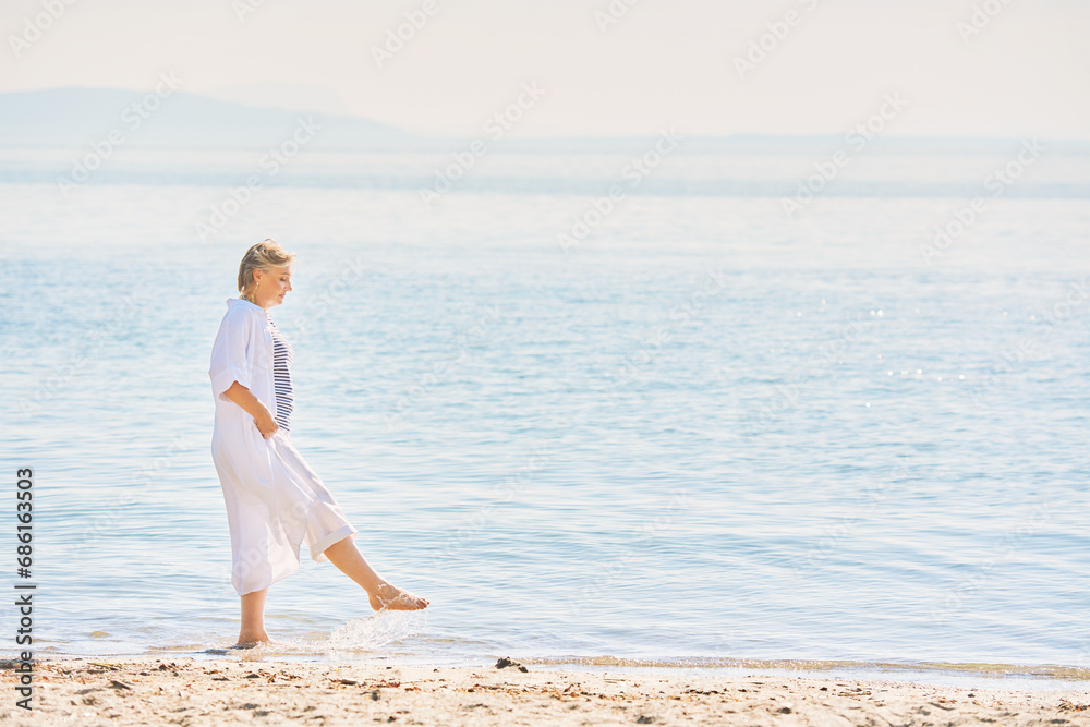 Outdoor summer portrait of happy and healthy mature 50 - 55 year old woman enjoying nice sunny day by the lake or sea, active lifestyle Outdoor summer portrait of happy and healthy mature 50 - 55 year old woman enjoying nice sunny day by the lake or sea, active lifestyle