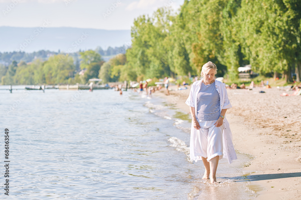 Outdoor summer portrait of happy and healthy mature 50 - 55 year old woman enjoying nice sunny day by the lake or sea, active lifestyle, image taken in Preveranges, Switzerland Outdoor summer portrait of happy and healthy mature 50 - 55 year old woman enjoying nice sunny day by the lake or sea, active lifestyle, image taken in Preveranges, Switzerland