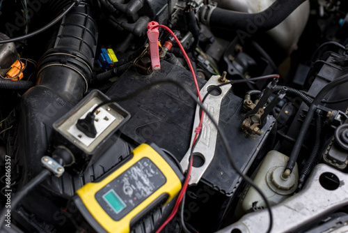 Engine engineer is recharging car battery because car battery is depleted. concept car maintenance.