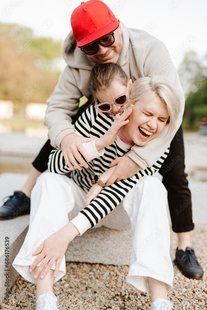 Fototapeta premium Young family with their daughter at park having fun together