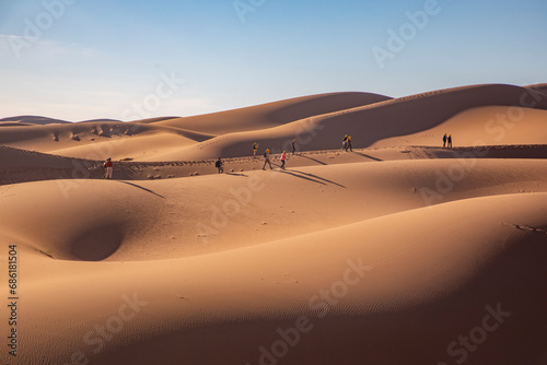 a group of hikers trekking through golden sands  united in their desert adventure.