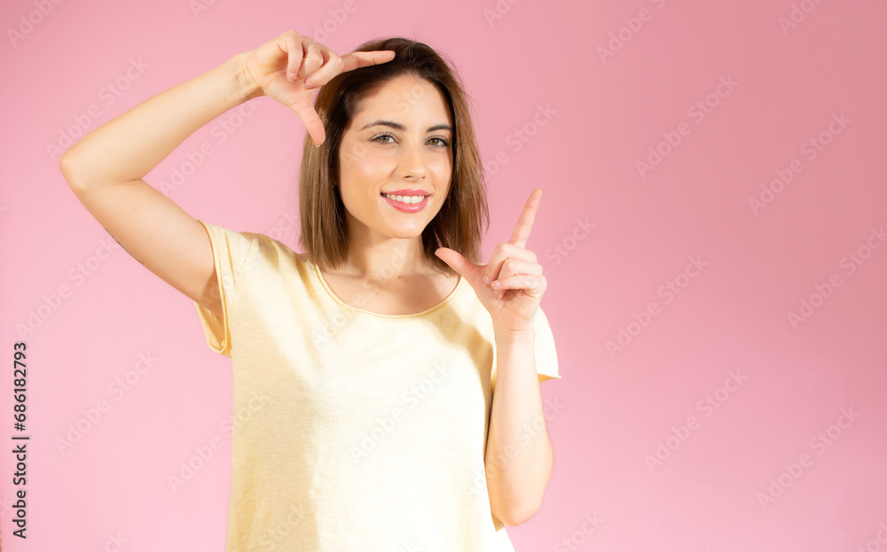 Happy woman making frame with fingers isolated on a pink background Happy woman making frame with fingers isolated on a pink background