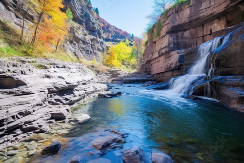 Peaceful scene of a clear, still stream reflecting a lush green forest in a red rock canyon