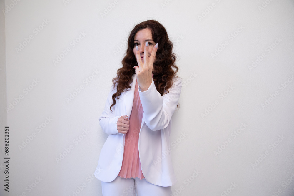 Beautiful brunette woman showing three fingers on white background Beautiful brunette woman showing three fingers on white background