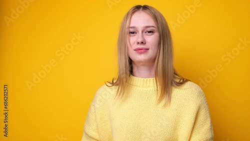 Cute girl sneezing and coughing on yellow background. The concept of a cold or allergies. photo