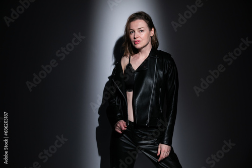 Portrait of a beautiful woman in 40 years old in black clothes in the dark