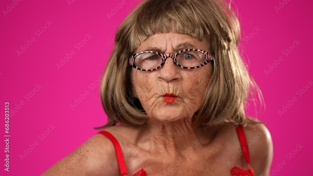 Closeup funny portrait of angry frustrated upset unhappy elderly old woman with no teeth isolated on pink background