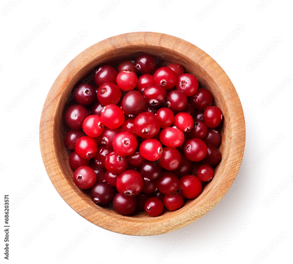 Cranberries in a wooden plate close-up on a white. Top view Cranberries in a wooden plate close-up on a white. Top view