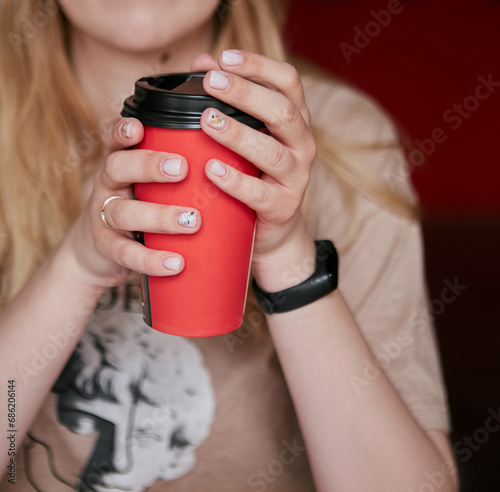 The girl is thinking and drinking coffee from a red cup