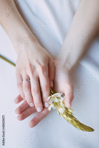 Close-up of a woman's hands holding a flower wedding photo