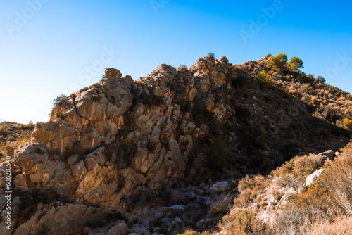 close up isolated photo of rich golden geometric mountain wall against blue sky for abstract © PopOff