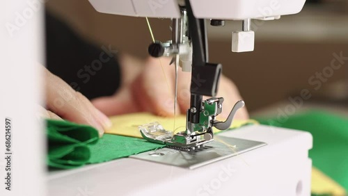 Close up footage of woman working on sewing machine in studio. photo