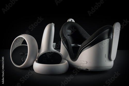 Virtual reality headset on a black background. VR glasses and video game controllers.