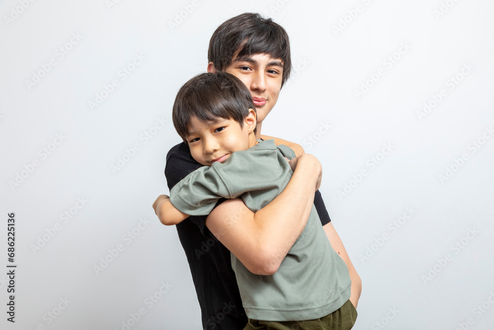 Adorable brother hugging standing on white background. Adorable brother hugging standing on white background.