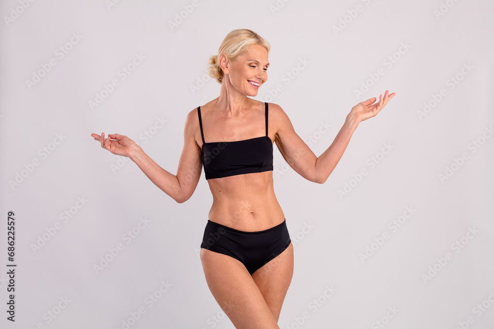 Photo of elegance pretty mature woman stylish underclothes fits sportive body healthy nutrition result isolated on gray color background Photo of elegance pretty mature woman stylish underclothes fits sportive body healthy nutrition result isolated on gray color background
