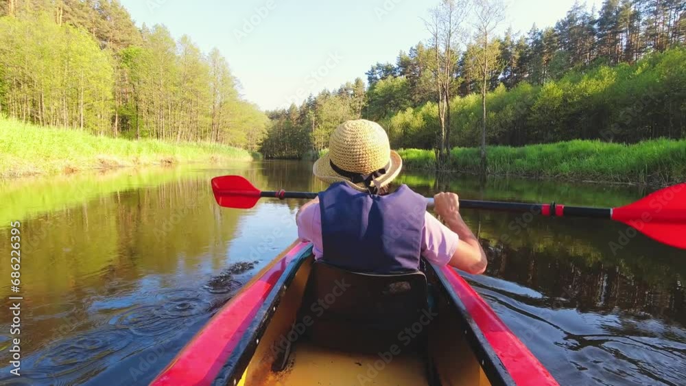 Back view Kayaking couple in river.POV of woman and man kayaking in Zemeina river, Lithuania. Aquatic sports during summer holidays concept.Beautiful hot summer day green landscape Back view Kayaking couple in river.POV of woman and man kayaking in Zemeina river, Lithuania. Aquatic sports during summer holidays concept.Beautiful hot summer day green landscape