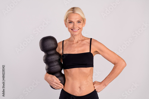 Photo of gorgeous confident aged lady hold mfr roller put hand skinny waist self care isolated on grey color background