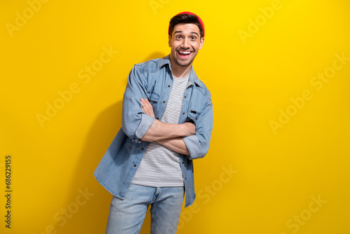 Photo of cheerful confident guy wear denim jacket smiling arms crossed empty space isolated yellow color background