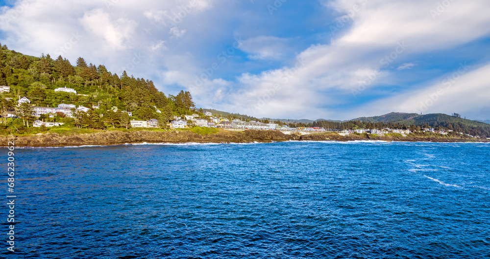 Aerial view of Depot Bay, Oregon waterfront with the blue waters of the Pacific Ocean lapping along the rocky shoreline. Aerial view of Depot Bay, Oregon waterfront with the blue waters of the Pacific Ocean lapping along the rocky shoreline.