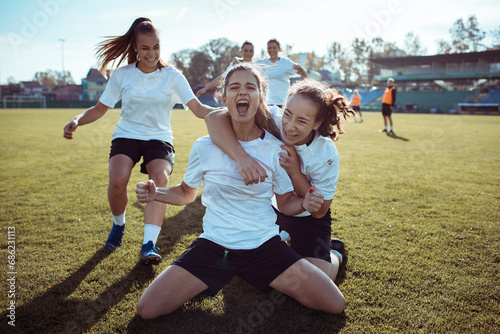 Female Soccer Players Celebrating Victory on the Field photo