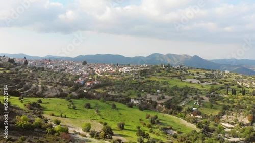 Aerial zoom in popular tourist attraction Pano Lefkara village on Cyprus, Europe. Flying over majestic cityscape with greek orthodox church on the beautiful green hills in summer photo