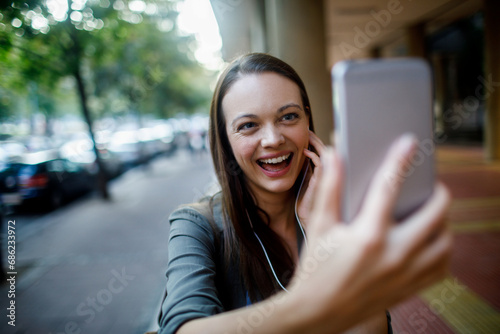 Happy Young Woman Taking a Selfie with Her Smartphone on a City Street