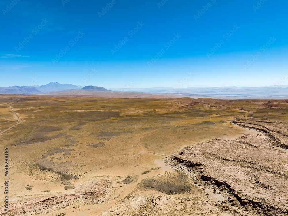 Região desértica ao lado do vilarejo de Socaire no Chile. Areia, dunas, céu azul e paisagem árida.
