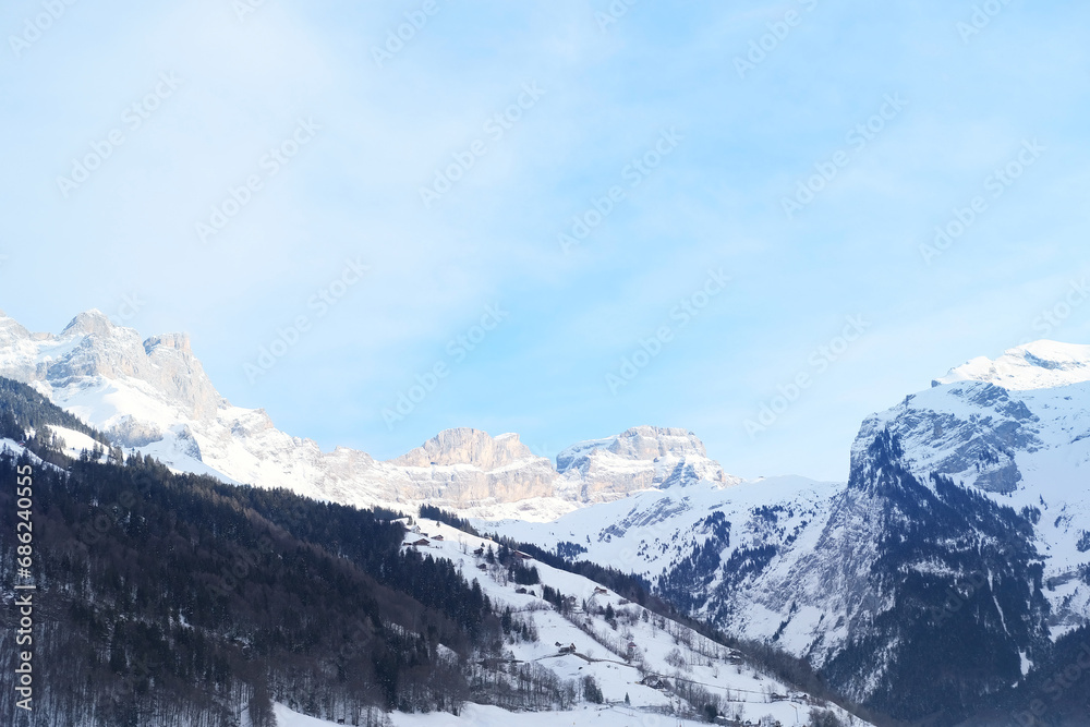 Naklejka premium beautiful winter landscape, snow-covered trees, mountainpass, snowfall in the mountains, Swiss Alps in the snow, walks in the winter white forest, tourism, winter sports