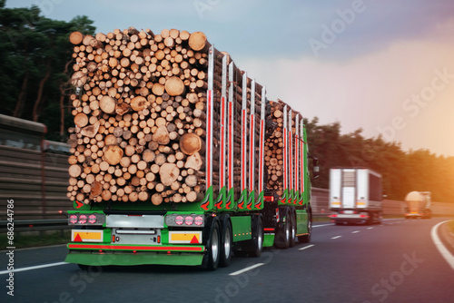 A Double Trailer Truck With A Cargo of Wooden Logs On A Motorway