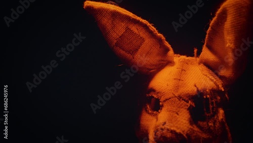 Soldier in a scary mask. A scary rabbit mask illuminated by a blinking light in a dark forest.
