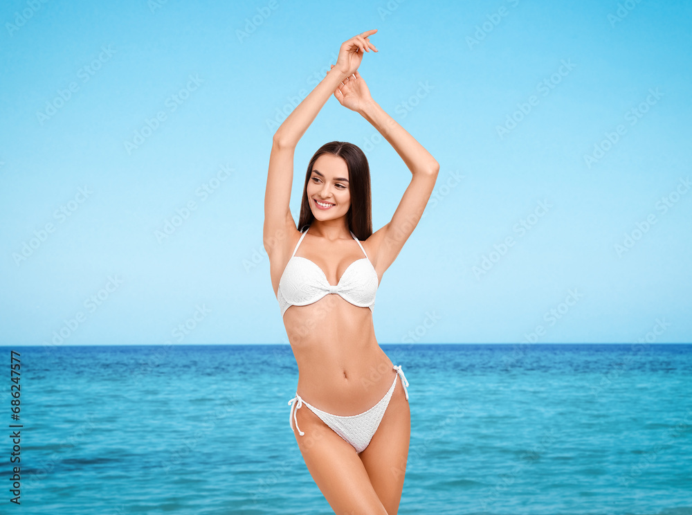 Happy woman in stylish white bikini near sea