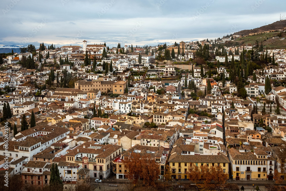 Evening city landscape with white houses and tiled roofs against the sky. Granada, Spain.