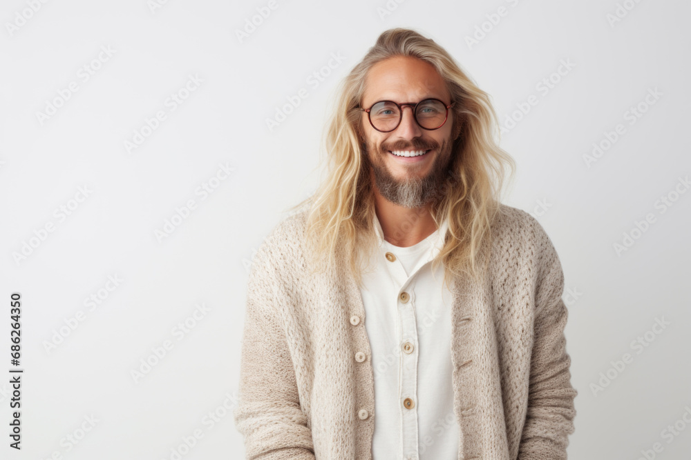 Portrait of a handsome European male model wearing prescription glasses and Norwegian knitted cardigan, studio shot