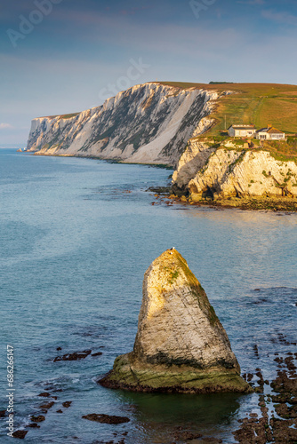 Early morning light hitting the Stag Rock at Freshwater Bay, with the white chalk cliffs of Tennyson Down in the background,  Isle of Wight. photo