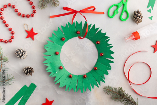 Christmas wreath from color paper with children. Step by step instructions. Handmade DIY new year holiday decoration project.