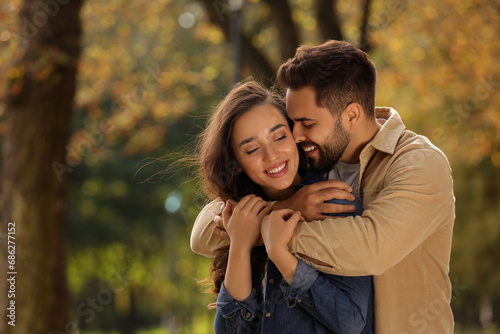 Beautiful couple hugging in autumn park, space for text