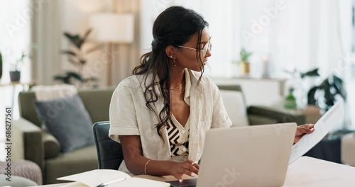 Woman, work from home and documents on computer for online research, financial planning and data report. Young worker or freelancer typing on her laptop with paperwork, bills and taxes in living room photo