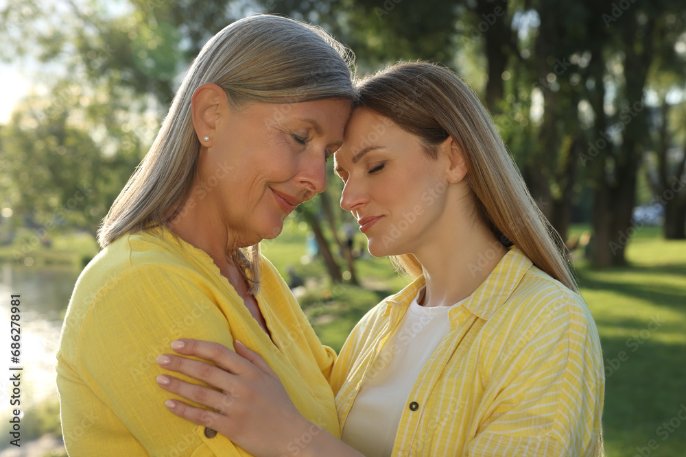Family portrait of happy mother and daughter spending time together in park on sunny day Family portrait of happy mother and daughter spending time together in park on sunny day